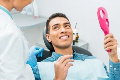 man loving the look of his cosmetic dentistry procedure at Optima Dental