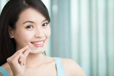 woman holding her Invisalign from Optima Dental