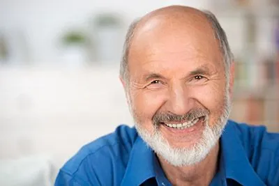 man with implant-supported dentures smiling